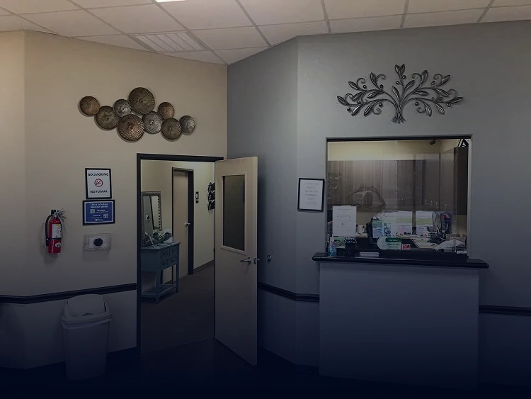Modern dental office interior with reception area, display cases, and wall-mounted decorative elements.