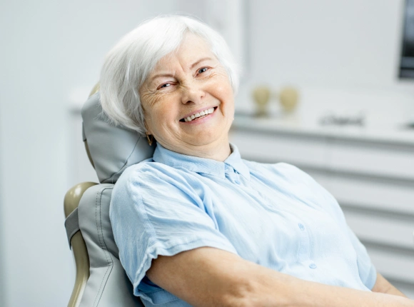 Senior woman smiling in dental chair at modern dental office