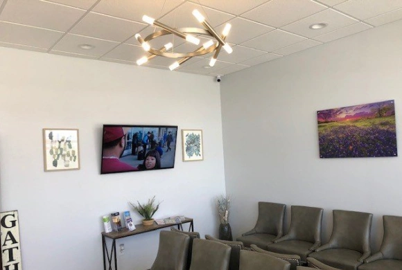 Modern dental waiting room with comfortable seating, wall art, and contemporary lighting fixtures.