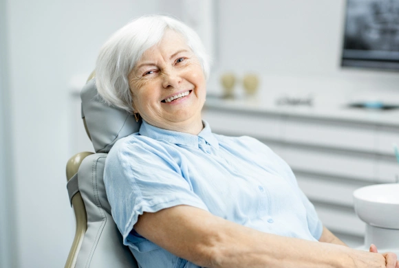 Senior woman smiling in dental chair at modern dental office