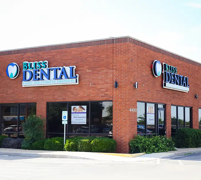 Exterior of Bliss Dental & Orthodontics brick building with signage and storefront windows.