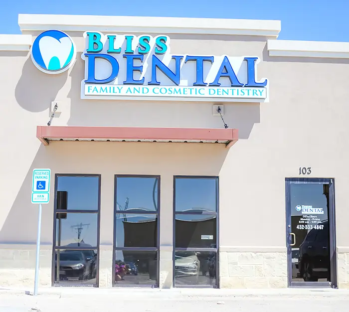 Bliss Dental & Orthodontics storefront with blue signage and glass entrance doors in strip mall setting.